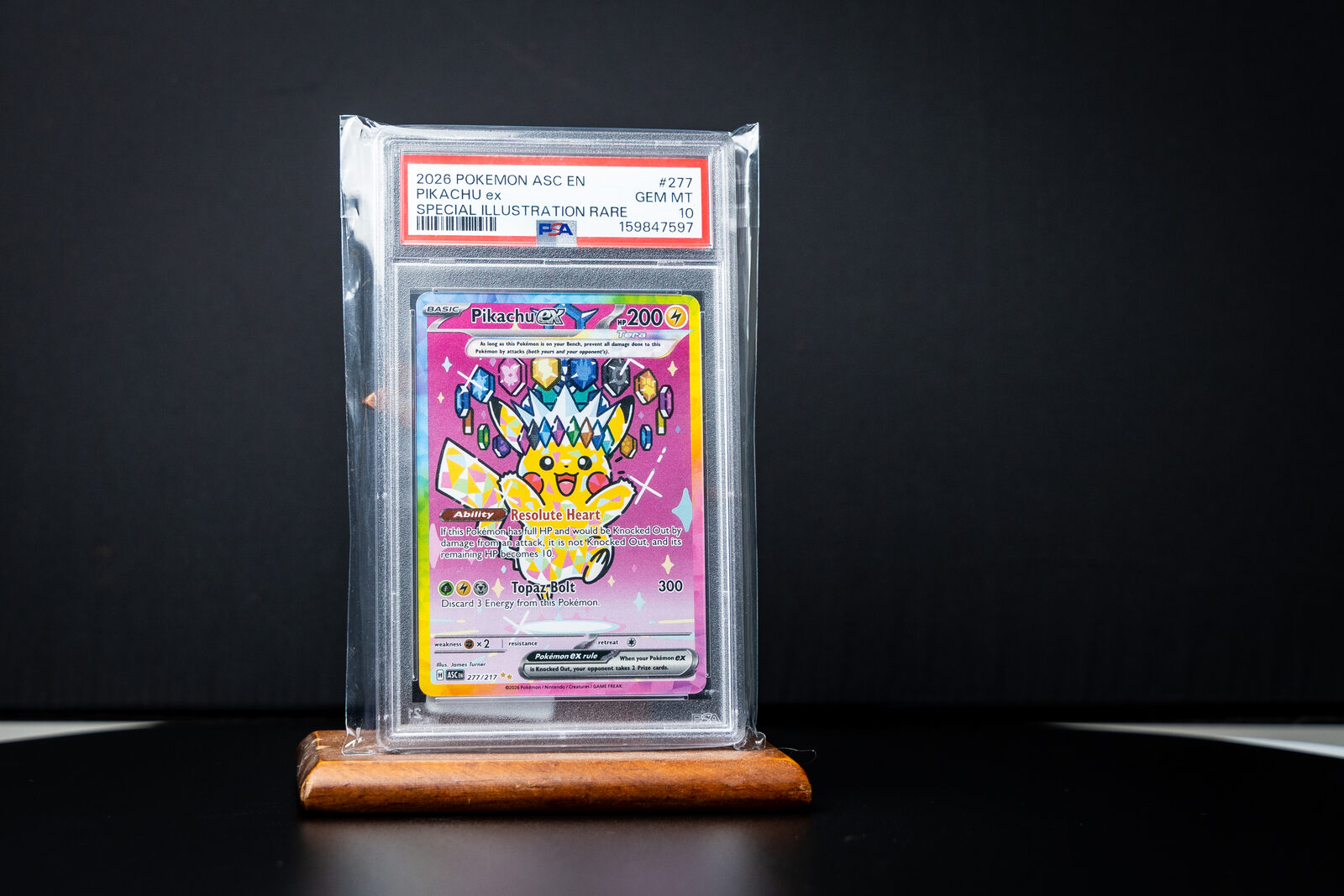 PSA 10 Pikachu ex Special Illustration Rare slab on a wooden stand against black